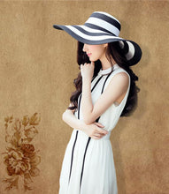 Load image into Gallery viewer, Black and white striped straw hat along the beach
